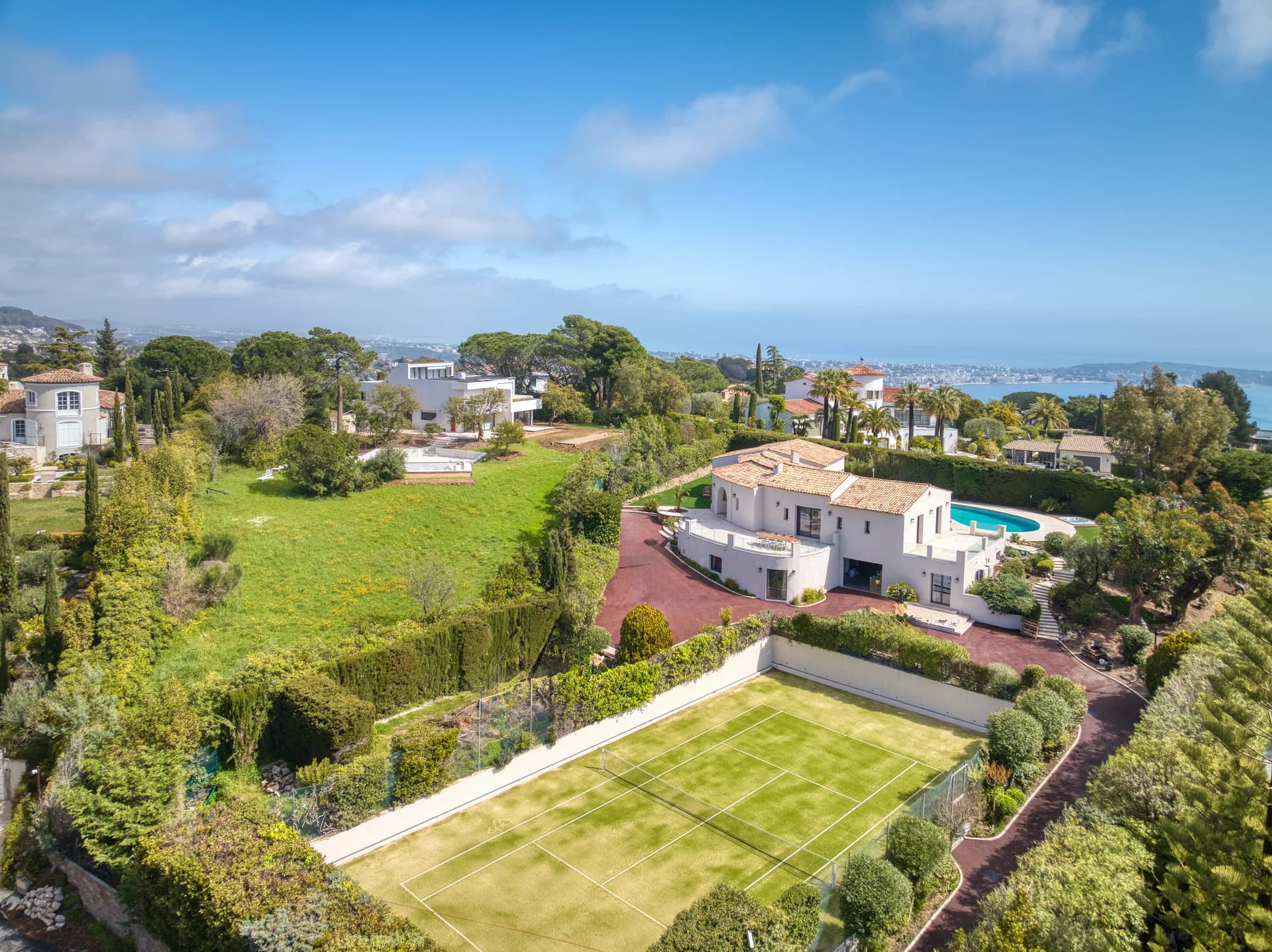 Vue aérienne du domaine : la villa, la piscine, le court de tennis et la baie de Cannes