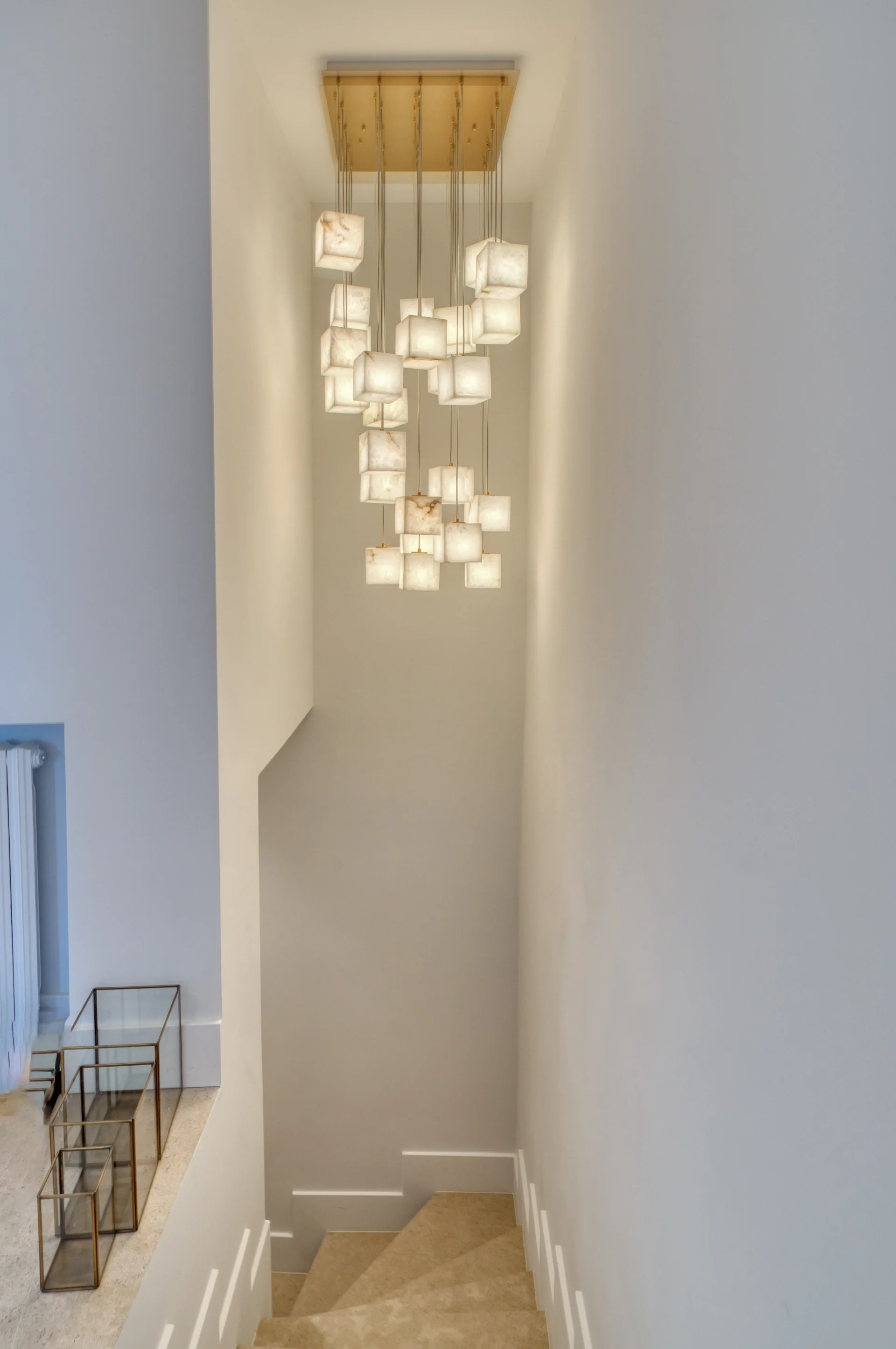 Cage d’escalier, lustre en cubes d’albâtre et garde-corps de verre