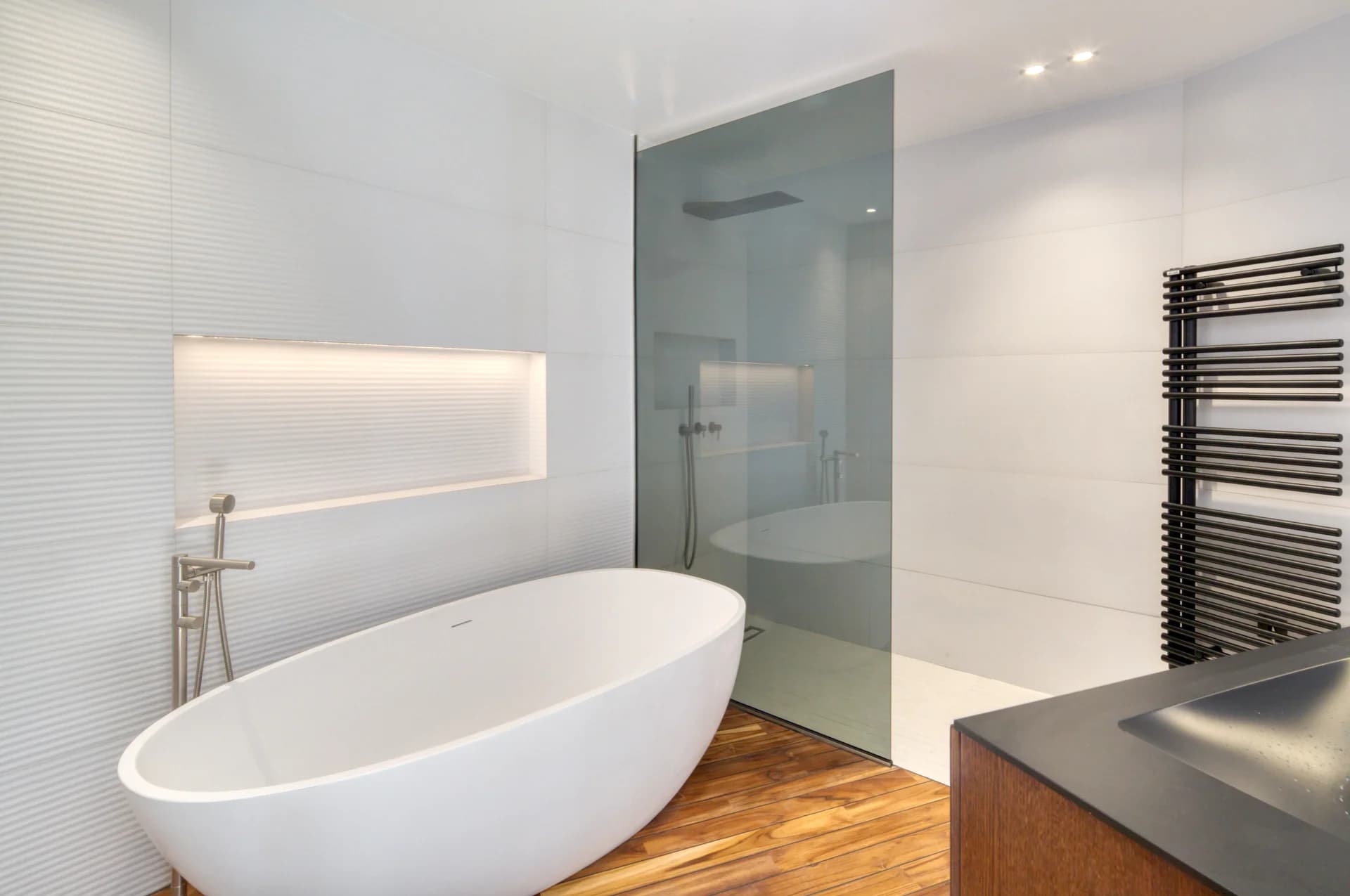 Salle de bain, baignoire îlot et douche derrière une paroi de verre