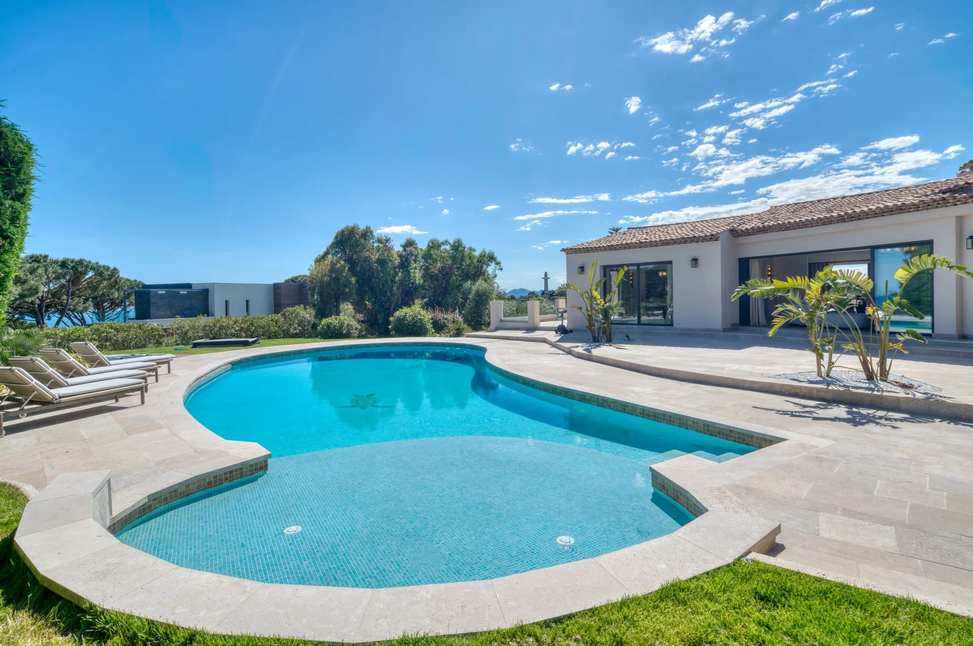 La piscine devant la villa, terrasse en pierre et transats
