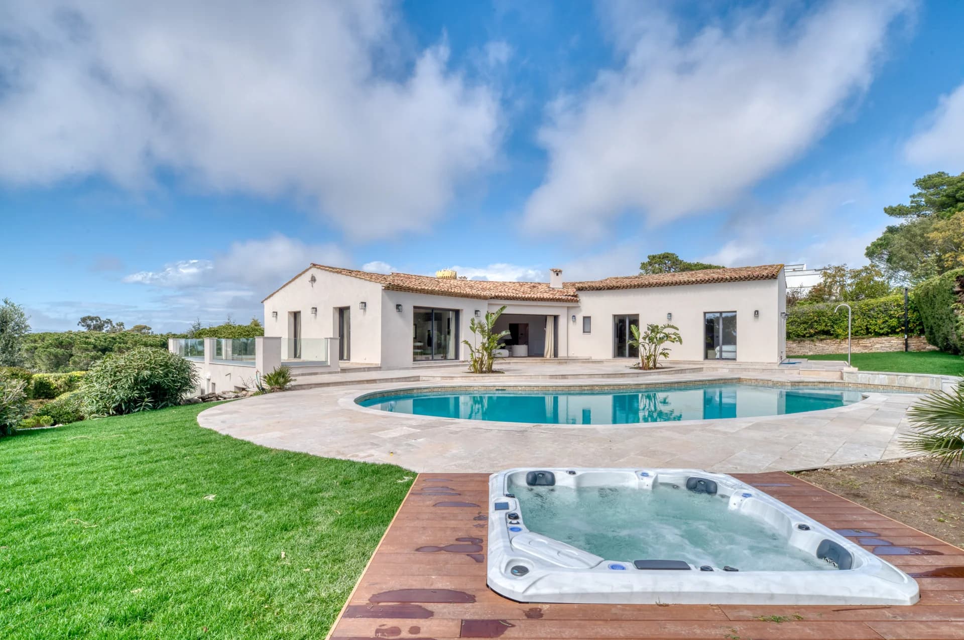 La villa depuis la pelouse, la piscine et le jacuzzi sur terrasse bois