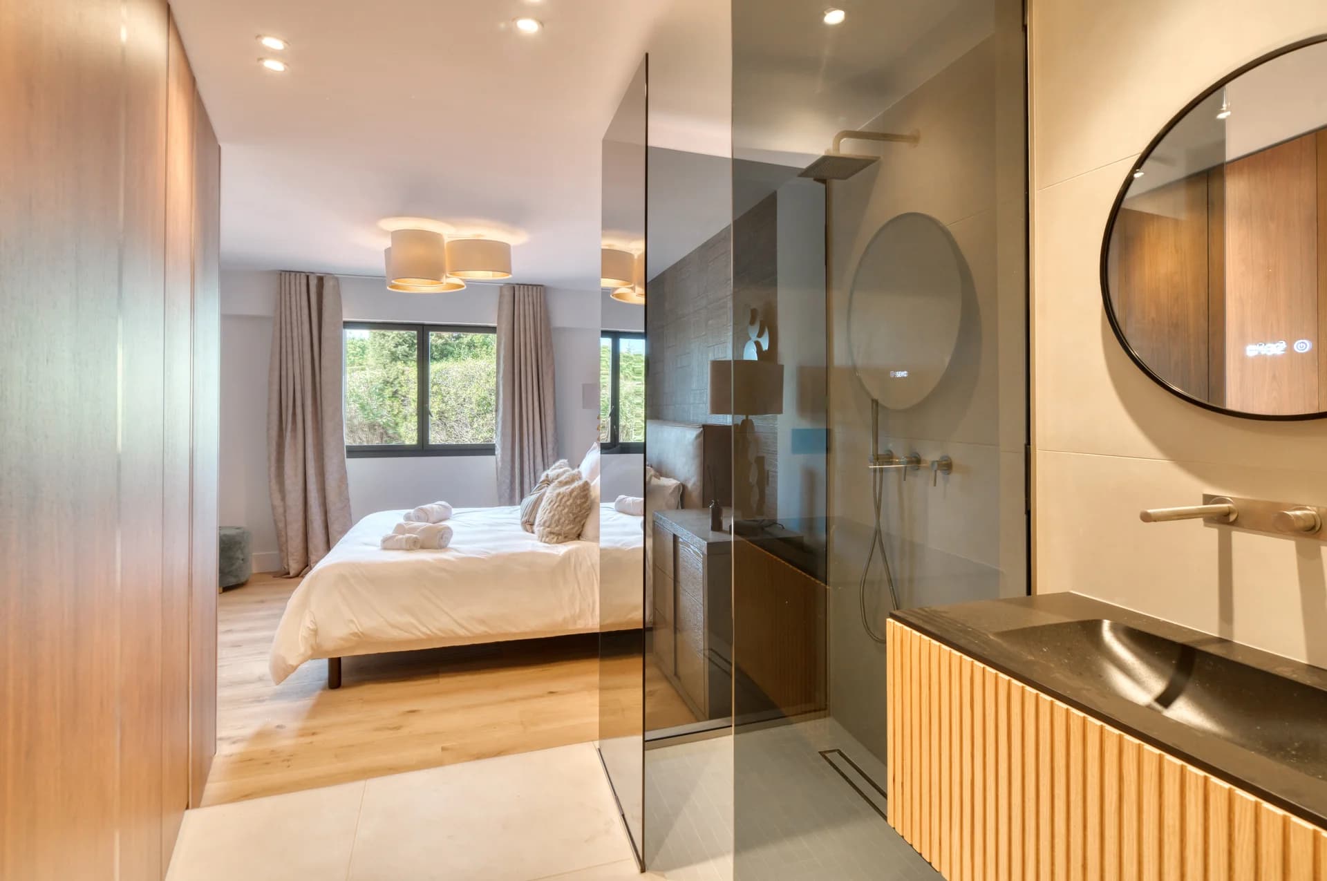 Suite avec salle d’eau ouverte, douche à l’italienne et vasque en pierre