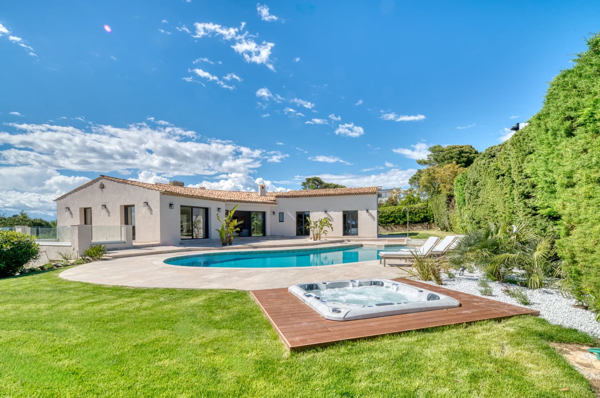 La villa vue du jardin, la piscine et le jacuzzi en terrasse