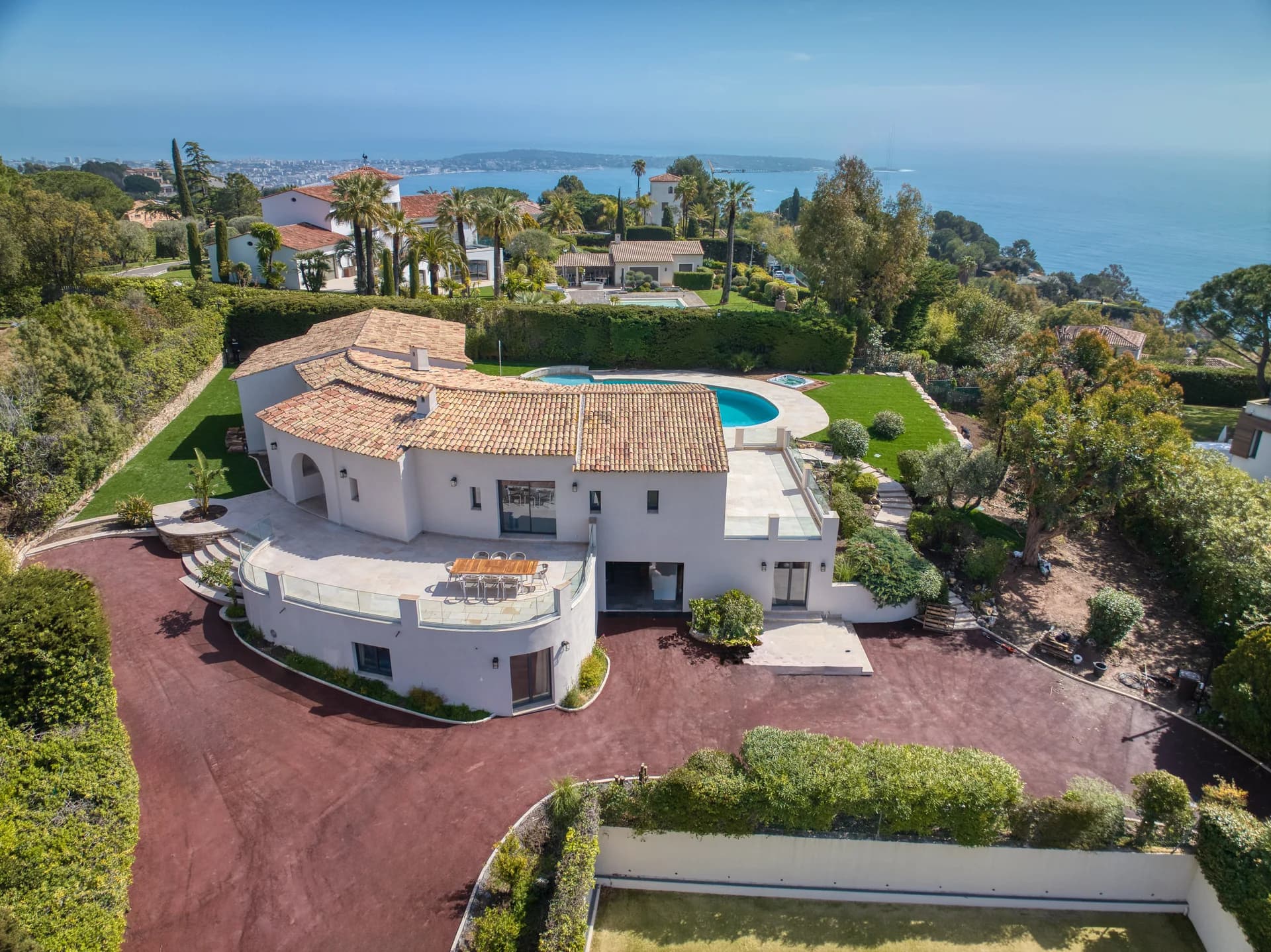 Vue aérienne de la villa : la terrasse en balcon, la piscine et son jacuzzi, la baie de Cannes au fond