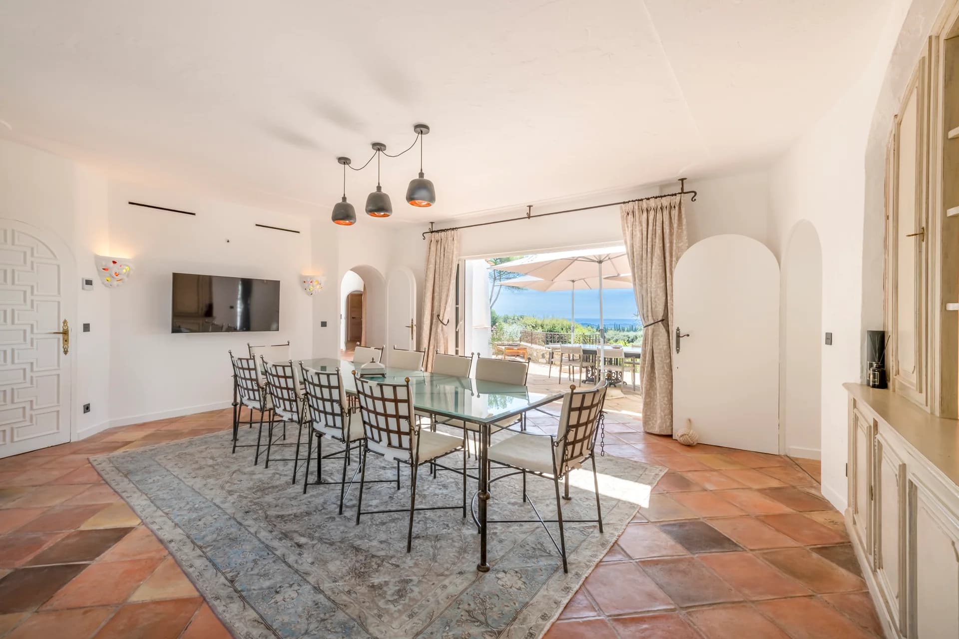 Salle à manger, table de verre pour dix et terrasse sur la mer