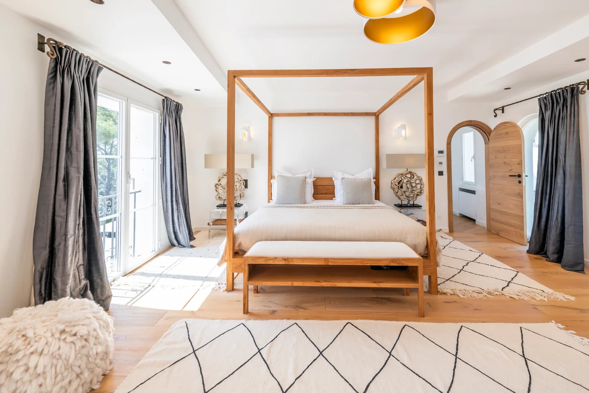 Suite principale, lit à baldaquin en teck et portes-fenêtres sur le balcon