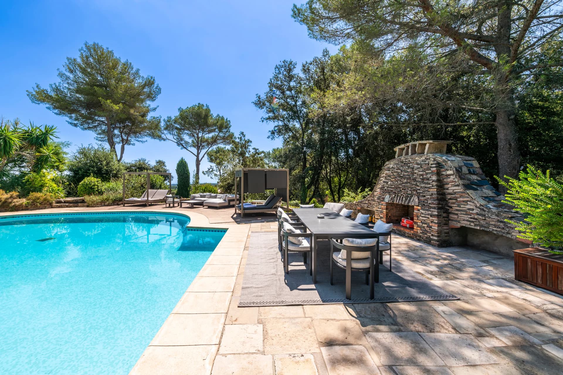 Table de repas au bord du bassin et cheminée de pierre sèche