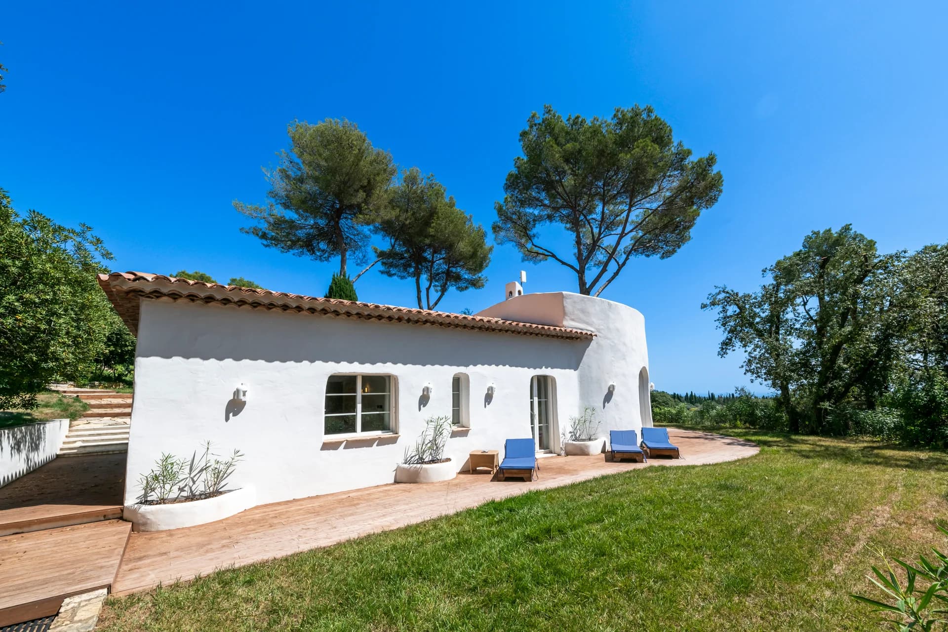 Façade de la maison d’amis, tuiles rondes et terrasse en bois