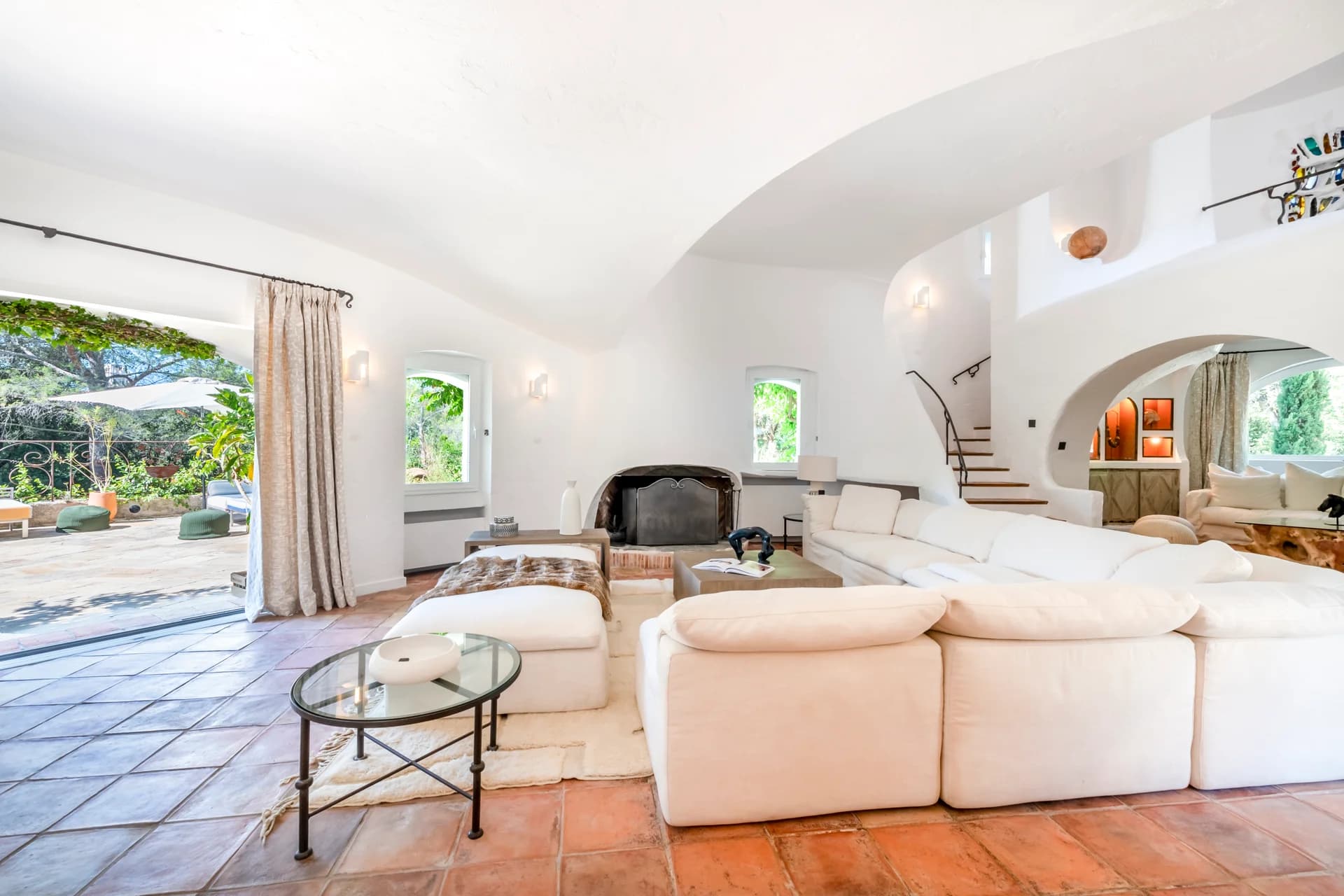 Salon blanc, cheminée et baie ouverte sur la terrasse