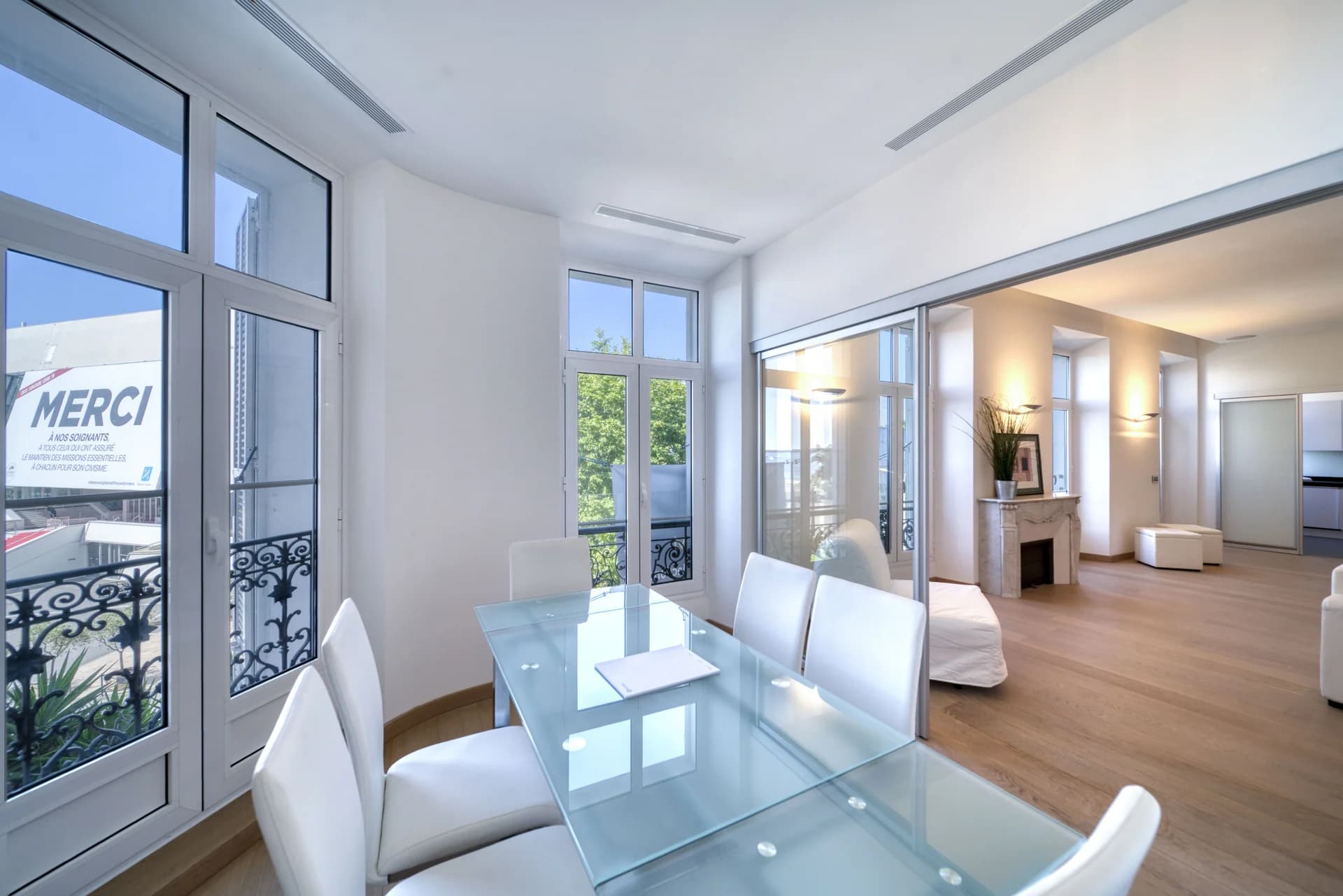 Salle à manger et table de verre face aux fenêtres