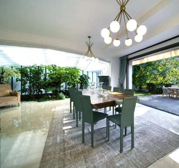 Salle à manger ouverte de part et d’autre sur le patio planté