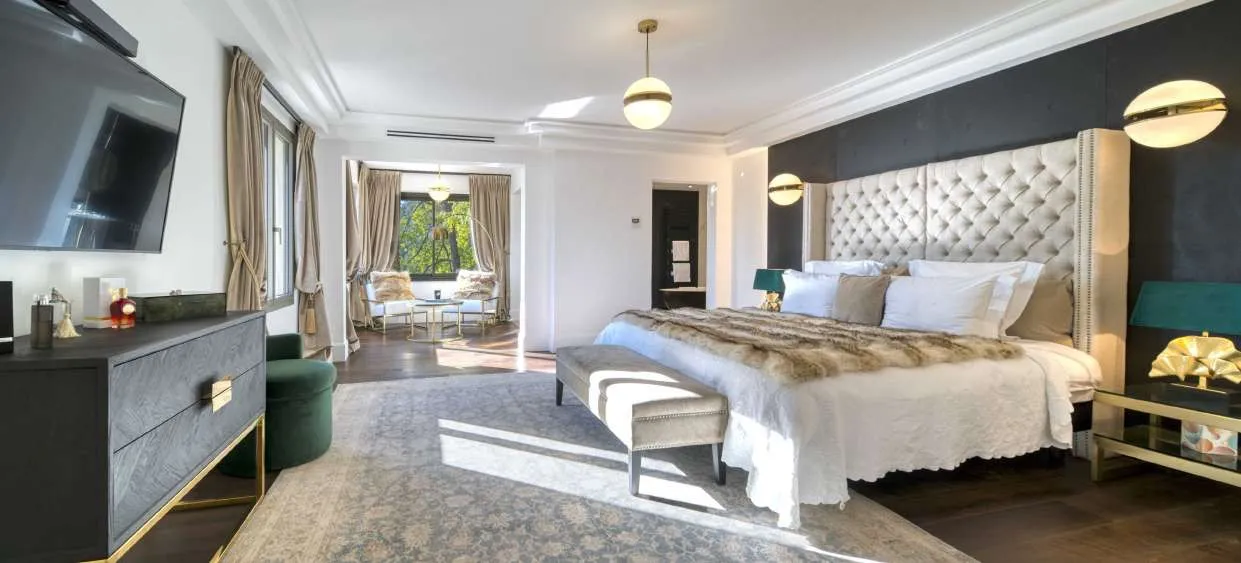Suite à tête de lit capitonnée, salon privé et porte-fenêtre sur le parc