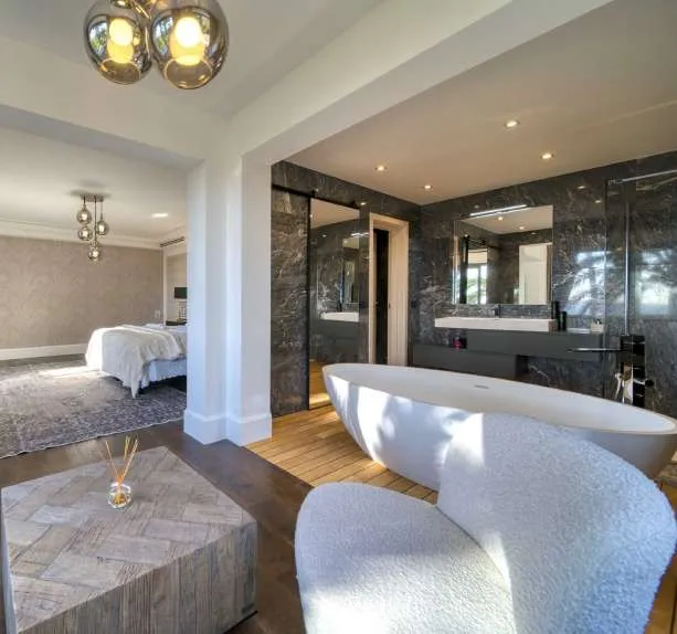 Chambre en suite et sa salle de bain de marbre à baignoire îlot
