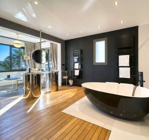 Salle de bain aux murs sombres, baignoire îlot noire et coiffeuse