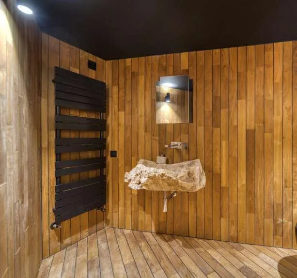 Salle d’eau lambrissée de bois, vasque taillée dans la pierre