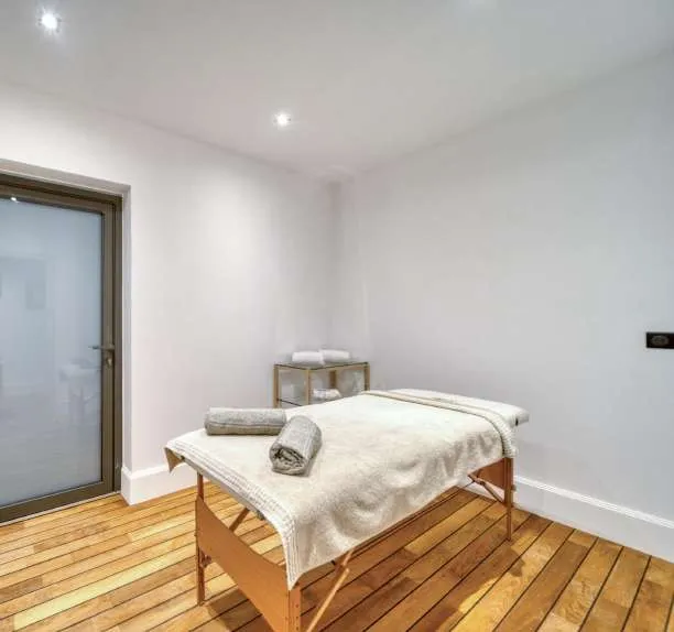 Salle de massage, table dressée de linge blanc