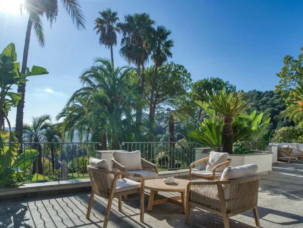 Salon de terrasse en bois, palmiers et horizon marin