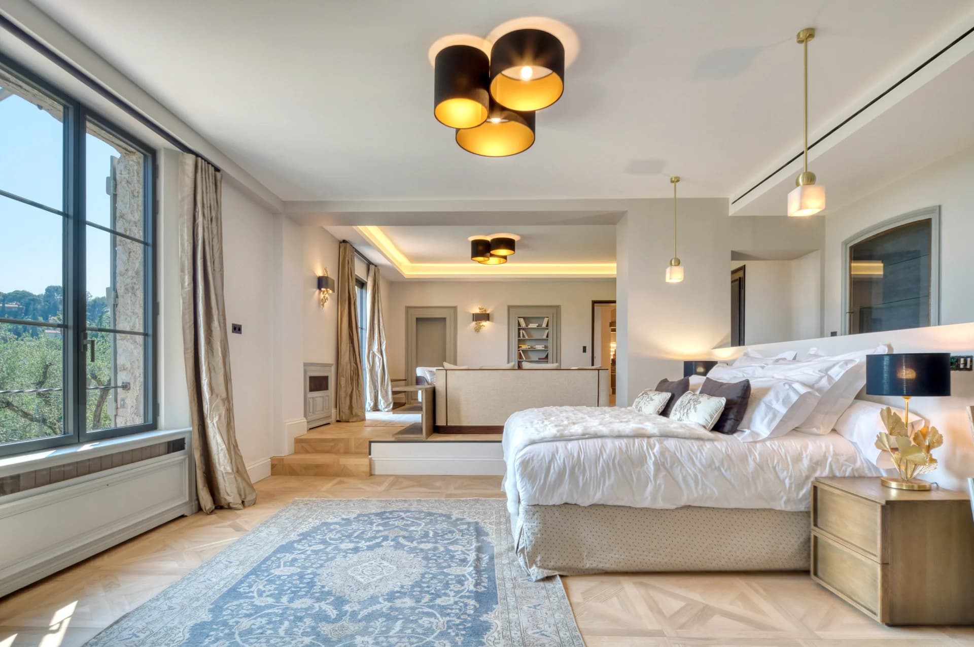 Suite principale, lit face aux fenêtres, salon en estrade et parquet marqueté