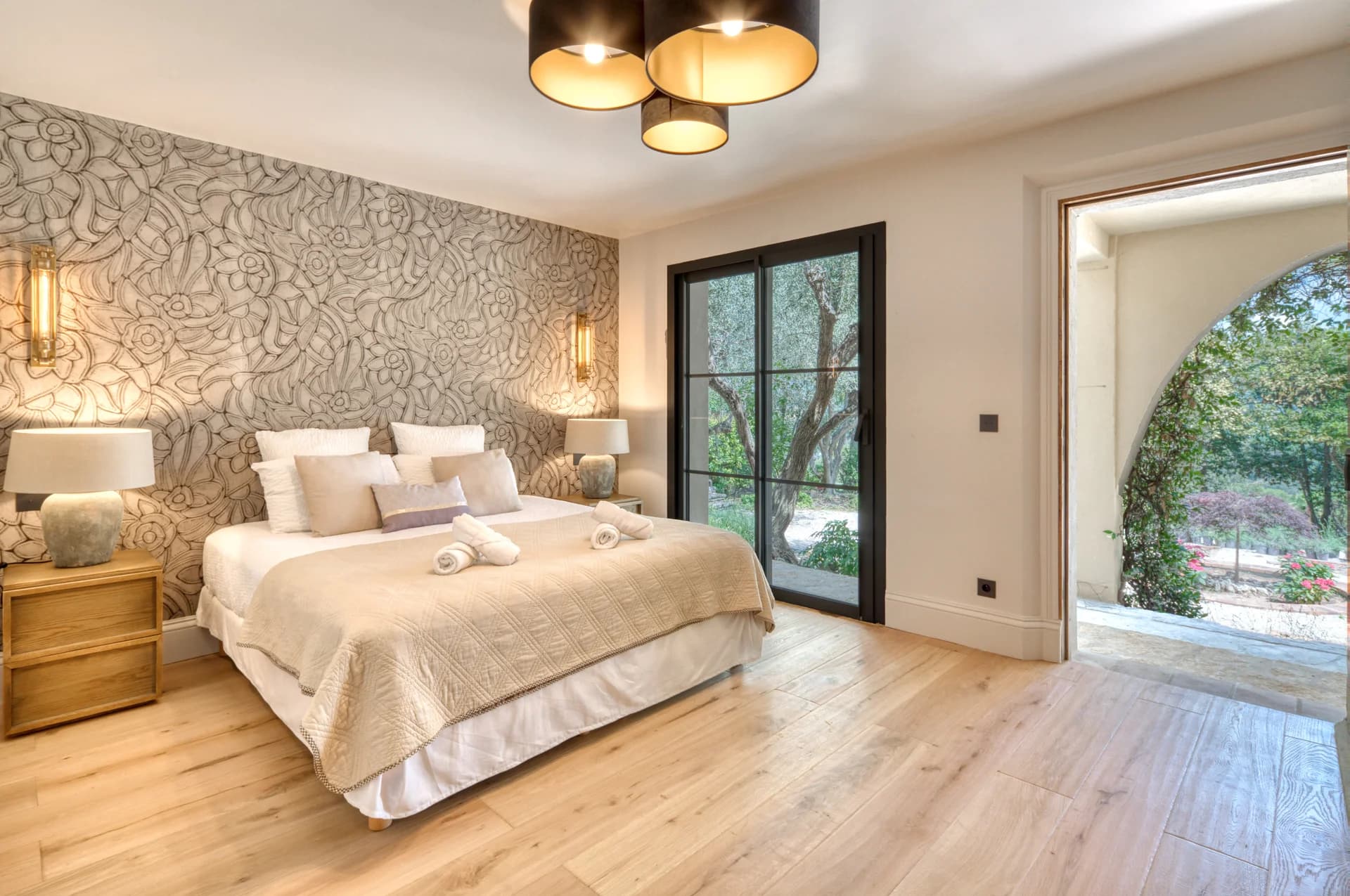 Chambre, mur fleuri en relief, baie vitrée et arche sur le jardin