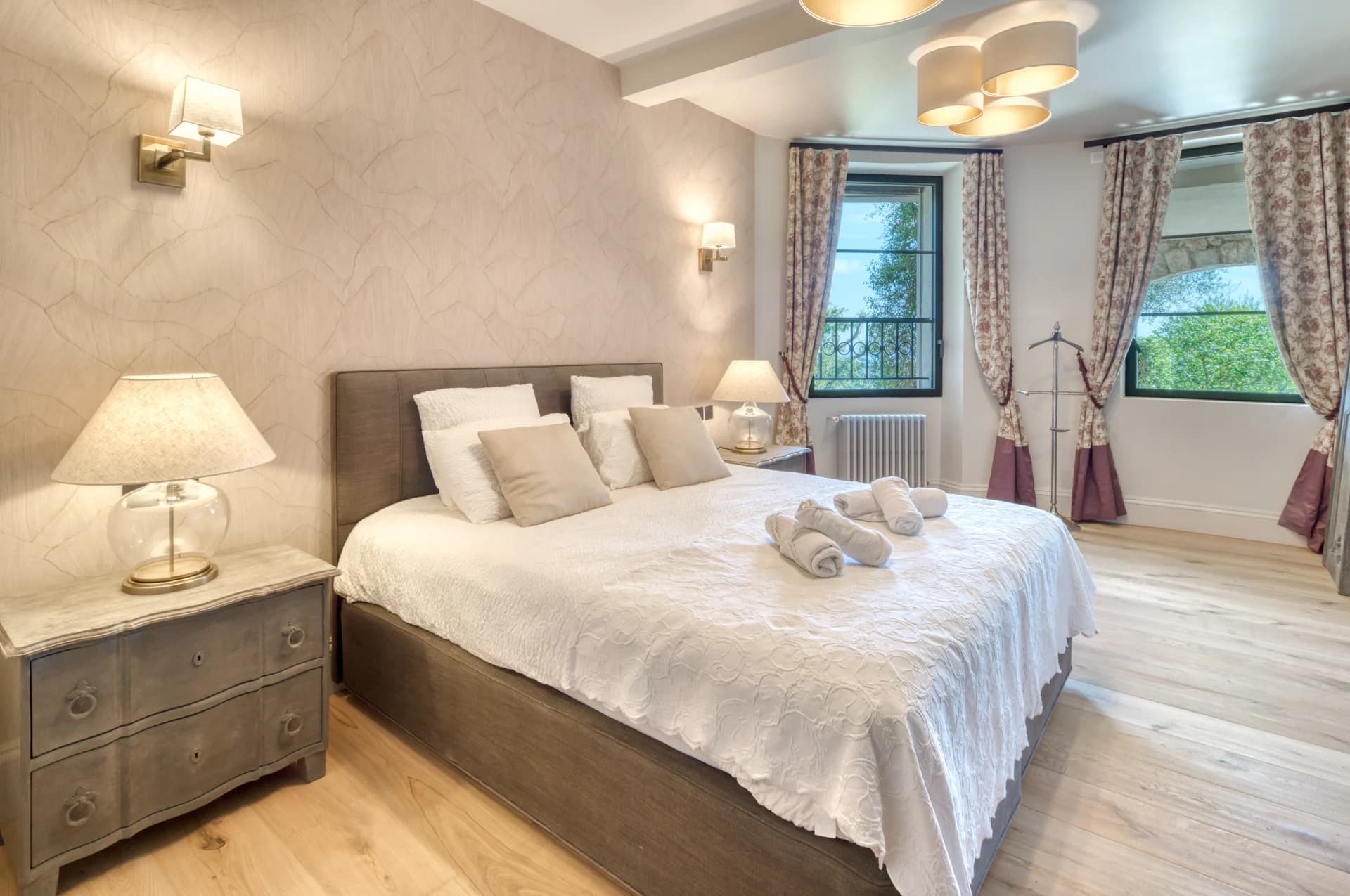 Chambre, tête de lit en lin, commode patinée et fenêtre sur les arbres